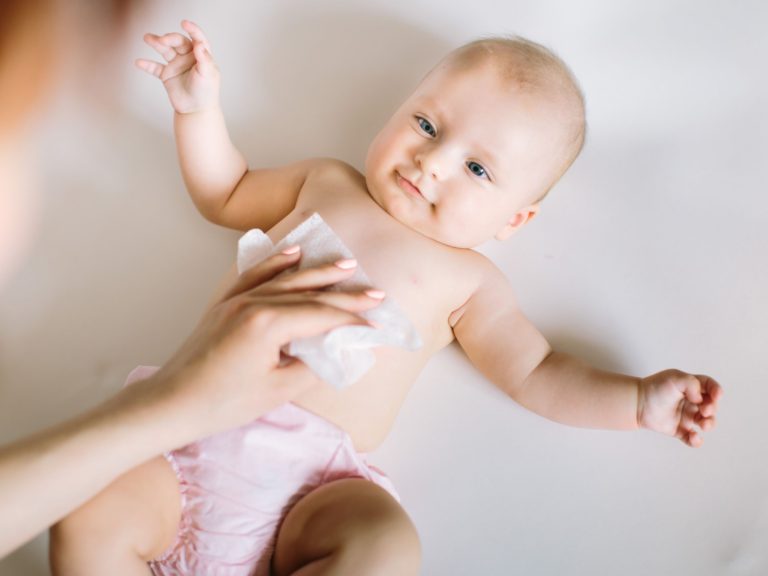 mother wiping baby with baby wipe
